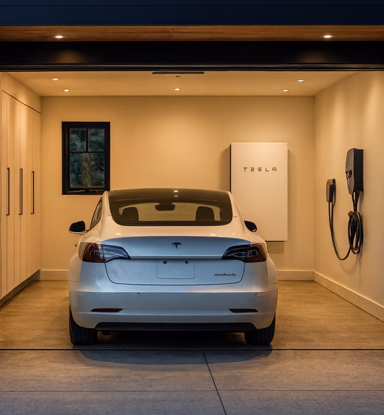 A car charging in a garage beside a home battery